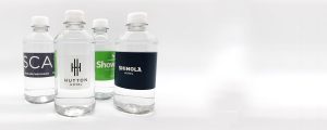 Four clear, plastic water bottles with custom labels