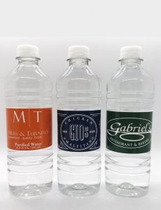 Three clear, plastic water bottles with custom labels