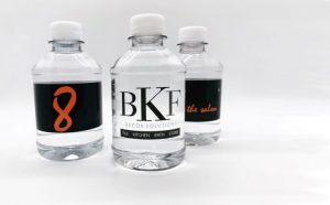 Three clear plastic water bottles with custom labels 