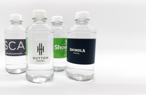 Four clear, plastic water bottles with customized labels 