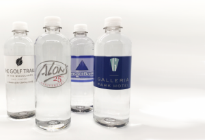 Four clear, plastic water bottles with custom labels 