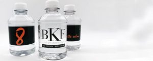 Three clear, plastic water bottles with custom labels