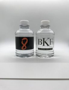 Two clear, plastic water bottles with custom labels