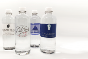 Four clear plastic water bottles with custom labels 