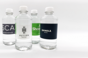 four plastic water bottle affixed with custom promo labels